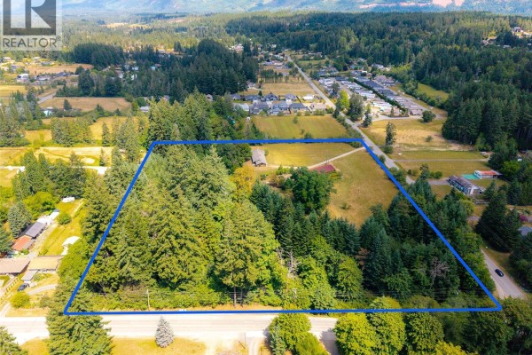 Aerial view of 5526 Grandview Rd, Port Alberni, showing the property with surrounding homes and distant hills. - 5526 Grandview Rd, Port Alberni