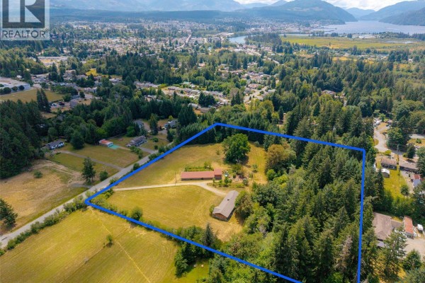 Wide aerial view of 5526 Grandview Rd, Port Alberni, highlighting the buildings and expansive land. - 5526 Grandview Rd, Port Alberni