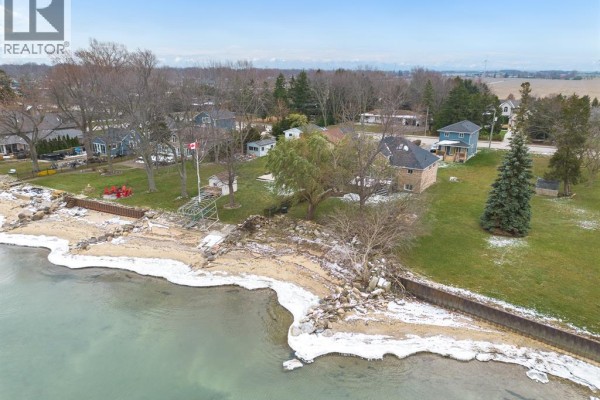 Aerial view of a waterfront property with a house, beach, and surrounding neighborhood. - 5530 St. Clair, Lakeshore