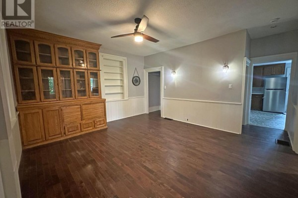 View of the room with built-in cabinet, leading to a hallway and a glimpse of a kitchen. - 555 Thornton Road S, Oshawa