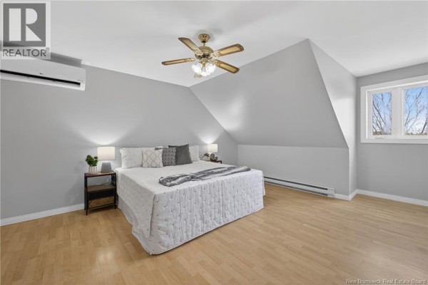 Bedroom with light wood floor, neutral walls, ceiling fan, and doorways to other rooms. - 5551 Route 11, Riviere Du Portage