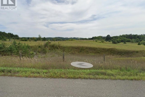 View of rolling fields and distant trees under a cloudy sky. - 557 Noonan Road, Alnwick/haldimand