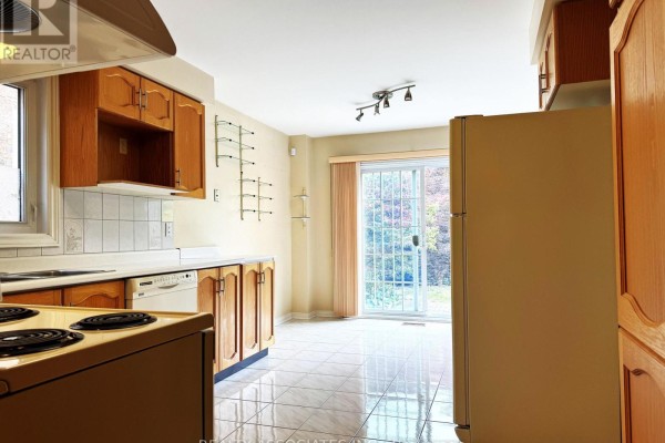 Kitchen with wood cabinets, white tiled backsplash, and a sliding glass door. - 5577 Haddon Hall Road, Mississauga