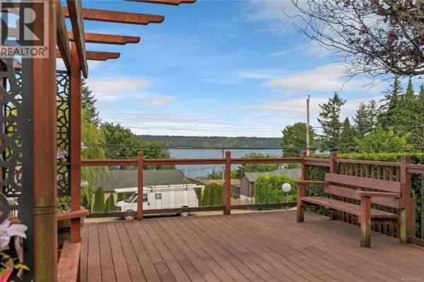 Concrete patio with garden pots and a white shed in the backyard. - 558 Alder St, Campbell River