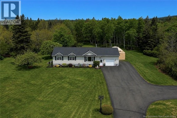 Aerial view of a home on a green lawn with a wooded background. - 558 Route 776, Grand Manan