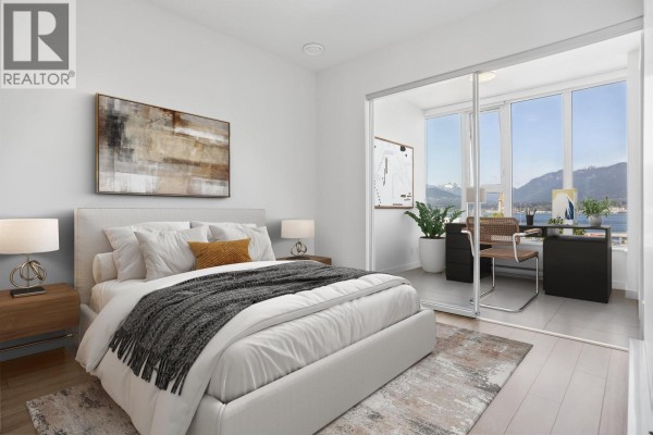 Bedroom with a bed, bedside tables, and sliding doors opening to a home office with water views. - 559 955 E Hastings Street, Vancouver