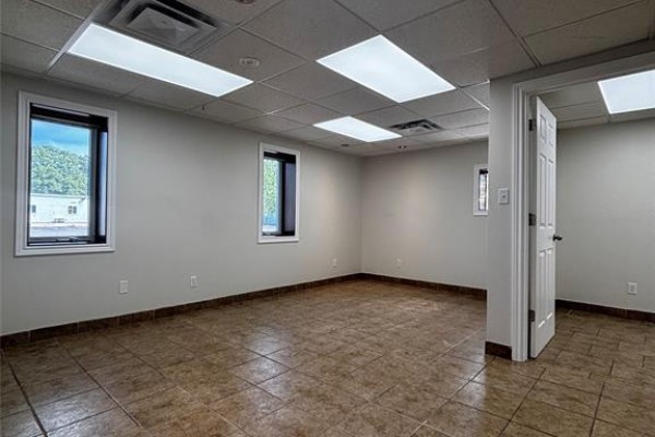 Interior commercial space with tiled floor, neutral walls, and dark framed windows. - 559 Exmouth Street Unit# C, Sarnia