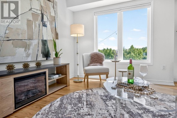 Living room with a fireplace, light wood flooring, large window with green view, and stylish furniture. - 56 - 28 Curlew Drive, Toronto