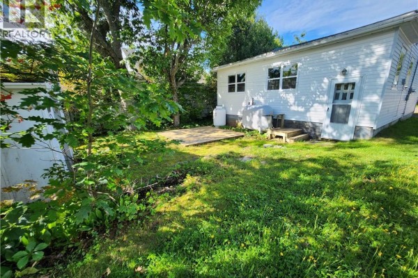Interior room with light grey walls, wood-look vinyl flooring, and a large window with curtains. - 56 Airport Street, Dieppe