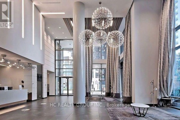 Lobby of a condo building with a reception desk, elevators, and modern decor. - 56 Forest Manor Road, Toronto