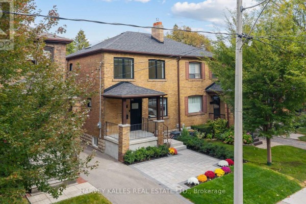 Aerial view of a brick semi-detached home with a paved driveway and landscaping. - 56 Glengarry Avenue, Toronto