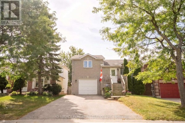 Front view of a detached brick house with a two-car driveway and mature trees. - 56 Hersey Crescent, Barrie