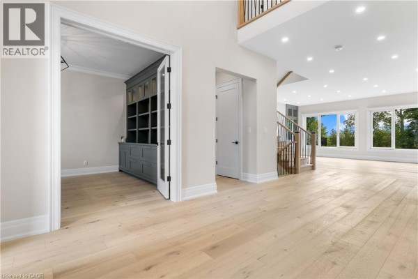 Open concept hallway with built-in cabinets, modern stairs and large windows - 56 Pioneer Ridge Drive Kitchener