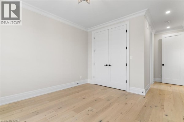 Light hardwood floors, double doors, and crown molding in a modern hallway - 56 Pioneer Ridge Drive Kitchener