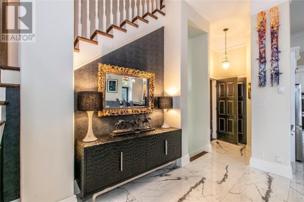 Hallway with a decorative console table, mirror, and a staircase leading upwards. - 56 Queens Road, St  John S