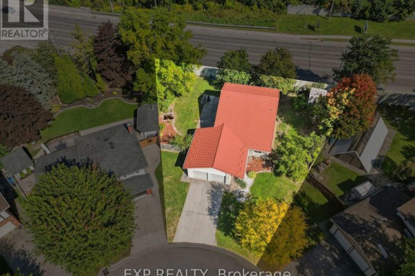 Aerial view of a residential property with a red roof, surrounding mature trees, and neighboring houses. - 56 Yardley Place, London North
