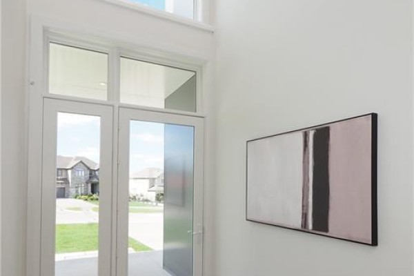 Double glass front doors opening to a bright foyer with abstract art. - 560 Werni Court, Waterloo