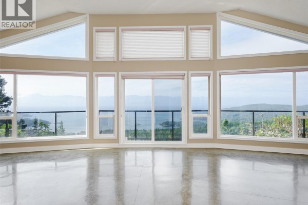 Living room with a sectional sofa, pool table, wet bar, and large windows with ocean views. - 560 Wilderness Pl, Sooke