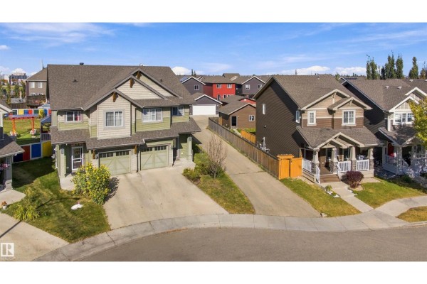 Aerial view of a duplex property with neighboring houses and a paved driveway. - 5604 Crabapple Wy Sw, Edmonton