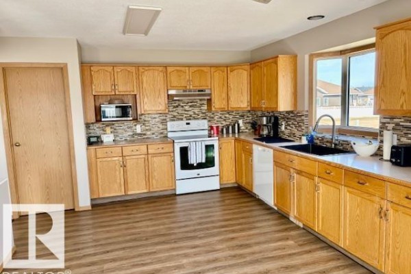Open concept living and dining area with wood furniture and laminate flooring. - 5609 45a St, Vegreville
