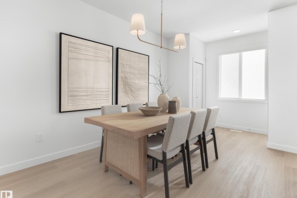 Dining room with a light wood table, woven chairs, and minimalist art on a white wall. - 5636 Hawthorn Wy Sw, Edmonton