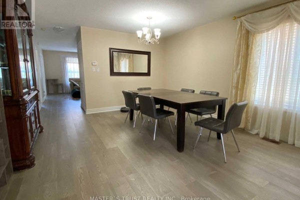 Formal dining room with a dark wood table, grey chairs, and beige walls. - 5659 Dolmite Heights, Mississauga