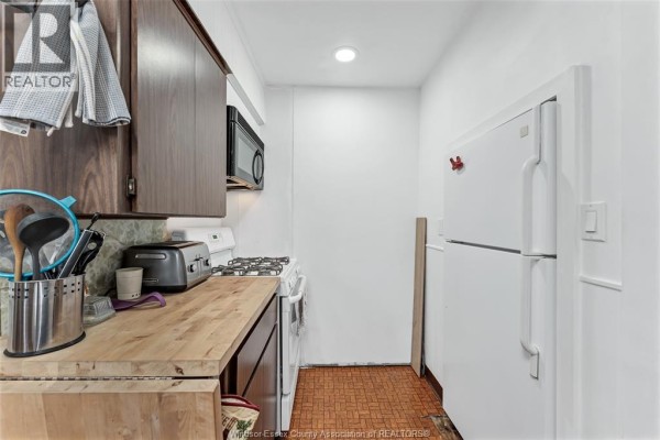 Kitchen with wooden countertops, stove, microwave, and refrigerator - 567 Edinborough Windsor