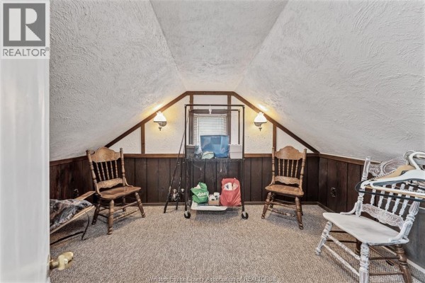 Attic room with fishing rods, wooden chairs, and sloped ceiling - 567 Edinborough Windsor