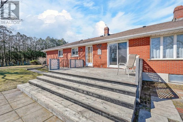 Deck and brick house exterior with stairs and trees - 568 7th Concession Enr Road Norfolk