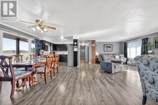 Living room with dining area, black kitchen cabinets, recliner, sofa, and wood-look floors - 568 7th Concession Enr Road Norfolk