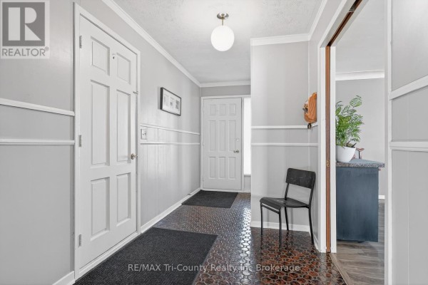 Hallway with two doors, black chair, and globe light fixture - 568 7th Concession Enr Road Norfolk