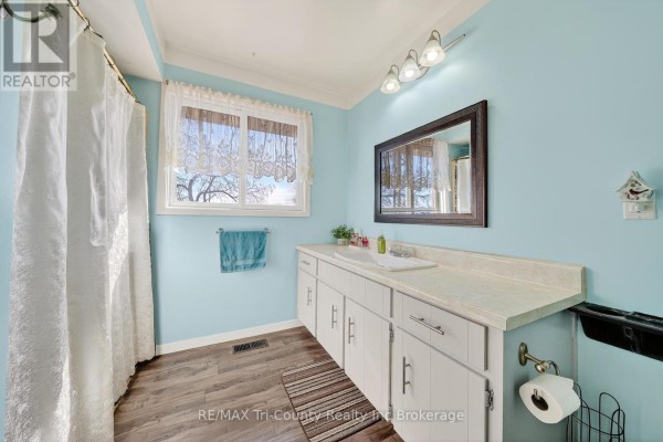 Bathroom with white vanity, blue walls, and a window - 568 7th Concession Enr Road Norfolk