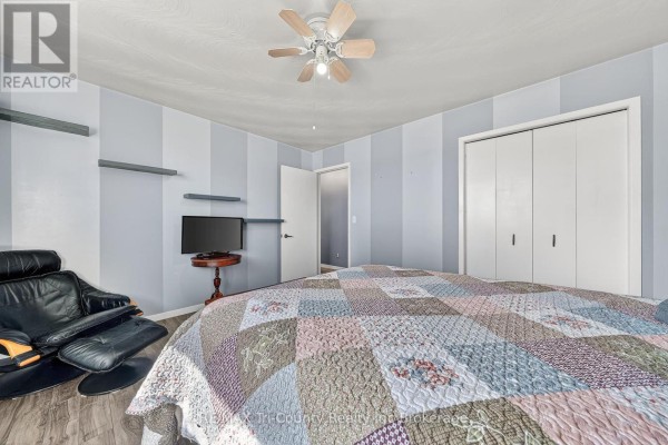 Bedroom with armchair, TV, and closet - 568 7th Concession Enr Road Norfolk
