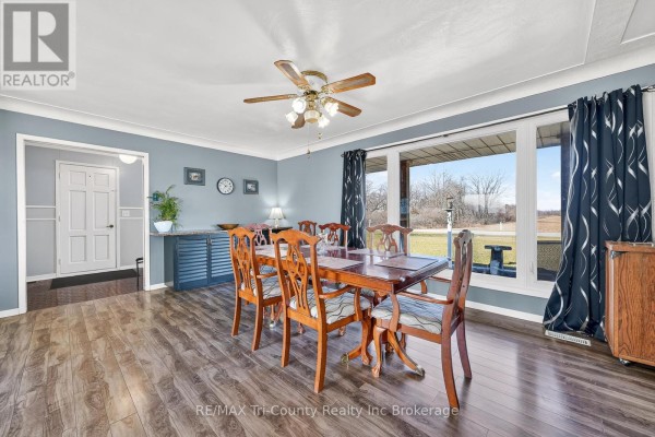 Dining room with wood table and chairs, large window view - 568 7th Concession Enr Road Norfolk