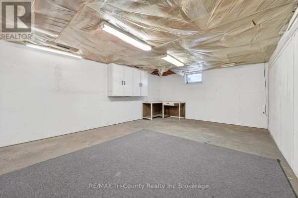 Basement with cabinets, desk, and fluorescent lighting - 568 7th Concession Enr Road Norfolk