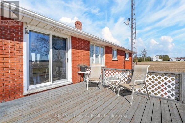 Deck with patio furniture and lattice railing overlooking fields - 568 7th Concession Enr Road Norfolk