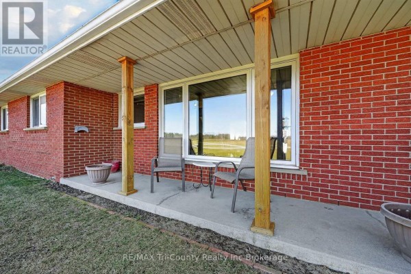 Covered porch with chairs and a table - 568 7th Concession Enr Road Norfolk