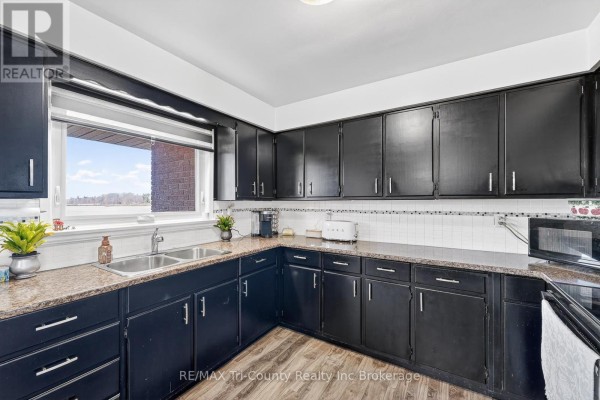 Kitchen with black cabinets, double sink, and view - 568 7th Concession Enr Road Norfolk