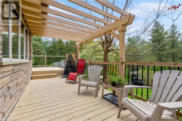 Chairs and a hot tub are situated on the wooden deck beneath a wooden pergola. - 569 Crane Court, Burlington