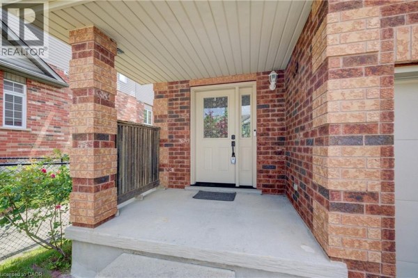 Close-up of the covered front porch with brick pillars and a glass-paneled front door. - 569 Violet Street, Waterloo