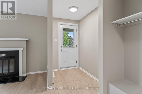 Spacious living room with light wood floors, grey walls, and a large window on the right. - 56a - 794 St. Andre Drive, Ottawa