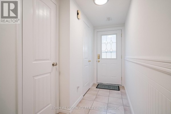 Entryway with white walls, tiled floor, and front door - 57 - 235 Bronte Street S, Milton