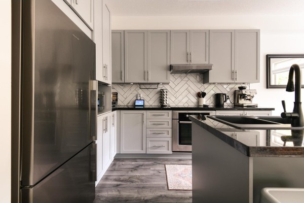 Kitchen nook with a round wooden table, four blue chairs, and a large window. - 57 2738 158 Street, Surrey
