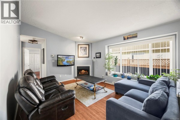 Living room view showing seating area, fireplace, and natural light from window - 57 7570 Tetayut Rd, Central Saanich