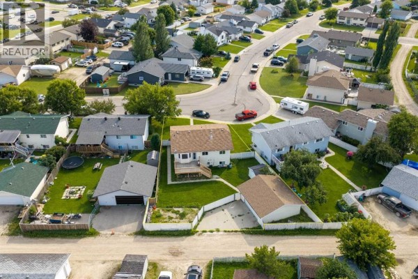 Aerial view of a residential street with houses, driveways, and vehicles. - 57 Atkinson Crescent, Whitecourt