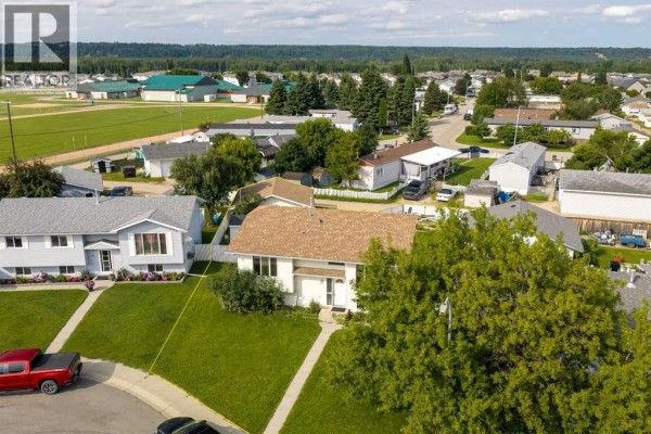 Aerial view showing the house and surrounding neighborhood with green spaces and other residences. - 57 Atkinson Crescent, Whitecourt