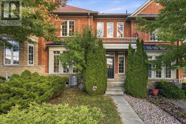 Exterior view of a red brick townhouse with a black fence. - 57 Barkdale Way, Whitby