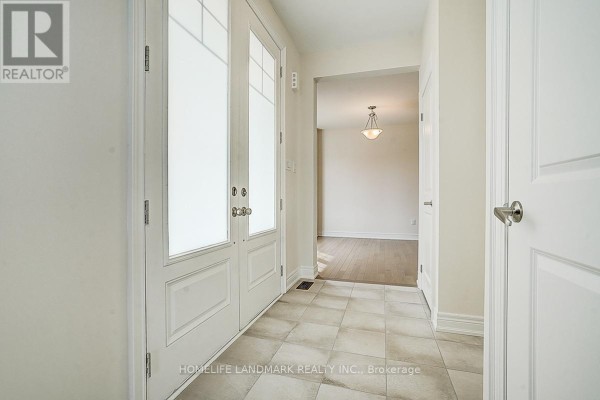 Hallway with beige tile floors, white doors, and double glass doors. - 57 Faimira Avenue, Georgina