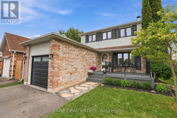 Front exterior of a brick and vinyl siding house with a garage and front porch. - 57 Fenwick Avenue, Clarington