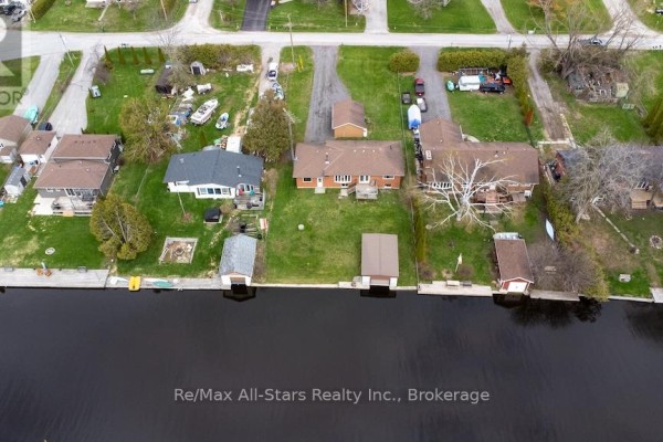 Aerial view of backyards with boathouses on canal and grassy area. - 57 Indian Trail, Kawartha Lakes